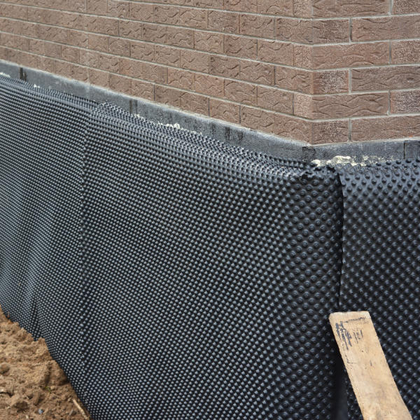 Kellerabdichtung von außen: Schwarze Wanne mit Bitumendickbeschichtung und Perimeterdämmung zum Schutz feuchter Kellerwände vor drückendem Wasser und aufsteigender Feuchtigkeit